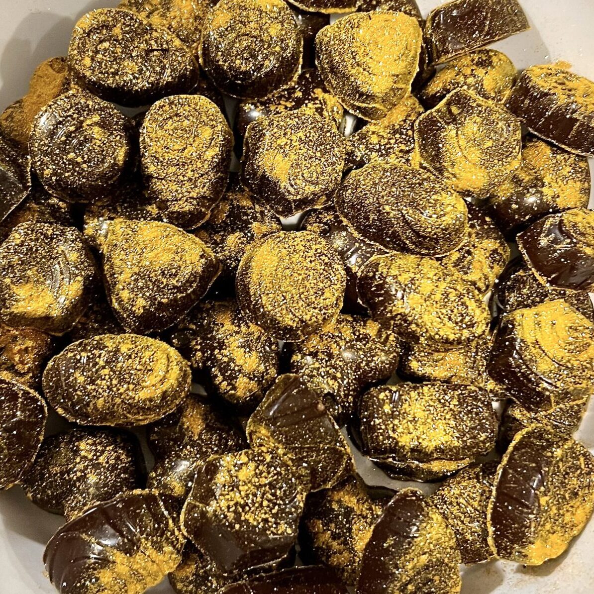 Chokladpraliner dekorerade med guldigt glitter.